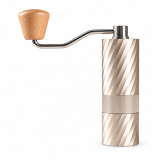 Champagne Gold Yozcoffee manual coffee grinder with textured center grip band and wood-knob crank on white