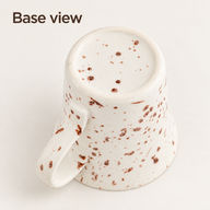 Tazza da caffè in ceramica capovolta che mostra la base puntinata e il manico curvo
