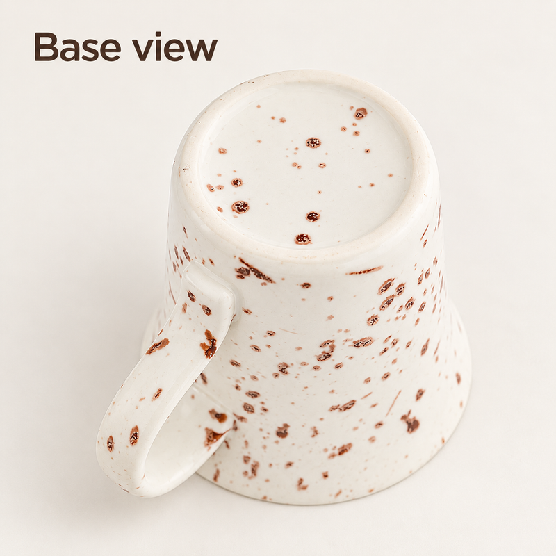 Tazza da caffè in ceramica capovolta che mostra la base puntinata e il manico curvo