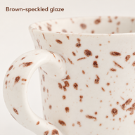 Primo piano dello smalto con puntinatura marrone sulla tazza in ceramica bianca e sul manico