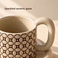 Close-up of the ivory cup's speckled ceramic rim, interior and oval handle