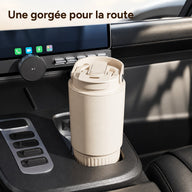 Gobelet beige latte de 800 ml, couvercle fermé et poignée repliée, dans le porte-gobelet d’une voiture