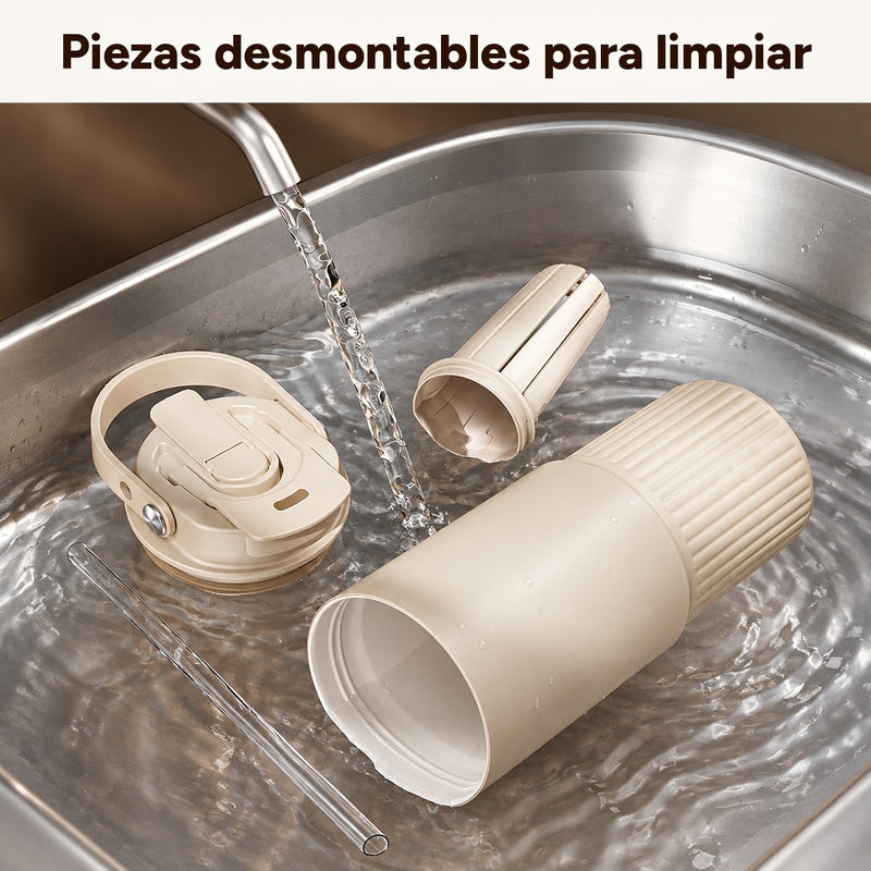 Vaso beige, tapa con asa, infusor de té y pajita transparente desmontados para enjuagarlos en el fregadero