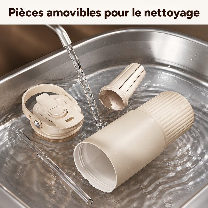 Gobelet beige, couvercle à poignée, infuseur à thé et paille transparente démontés pour le rinçage dans un évier