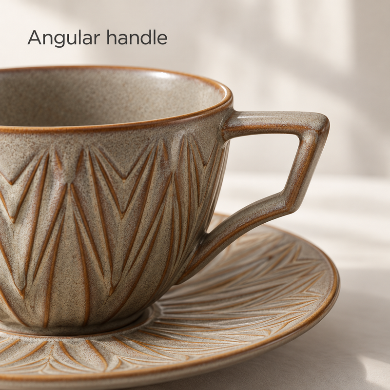 Close-up of the angular handle on the gray-taupe ceramic coffee cup