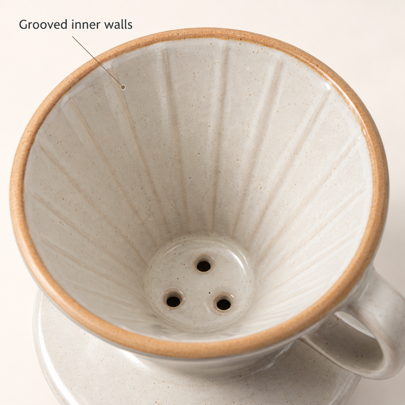Grooved interior and three drainage holes of the cream ceramic coffee dripper