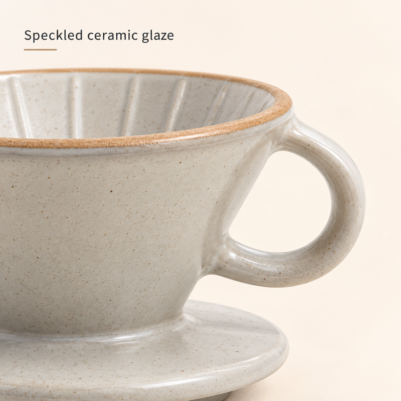 Close-up of speckled cream ceramic glaze, tan rim and loop handle