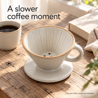 Cream ceramic pour-over dripper beside a cup of coffee by a window; cup not included