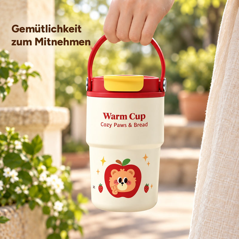 Roter Becher mit Keramikbeschichtung und gelber Deckelklappe, am roten Bügelgriff getragen auf einer Gartenterrasse