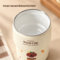 Geöffneter Becher mit weißer Keramikbeschichtung innen, dünnem Silberrand und brauner Aufschrift