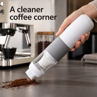 Handheld coffee grounds vacuum collecting dry grounds from a coffee counter