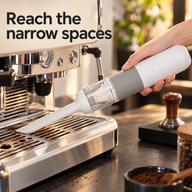 Long white crevice nozzle cleaning dry coffee grounds from an espresso machine drip tray