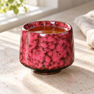 Tazza in ceramica con smalto cristallino rosso piena di tè su un piano della cucina soleggiato