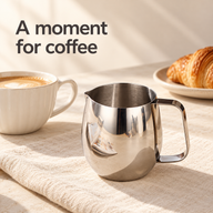 Silver egg-shaped milk pitcher beside coffee and a croissant on an ivory breakfast table