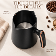 Close-up of the removable black jug showing the pouring rim, metal base and copper-tone handle trim