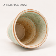 Innenraum der grünen Kaffeetasse aus Keramik mit marmorierter Glasur und konzentrischen Ringen