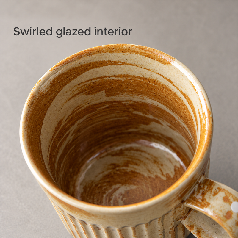 Close-up of the amber and cream cup's swirled glazed interior