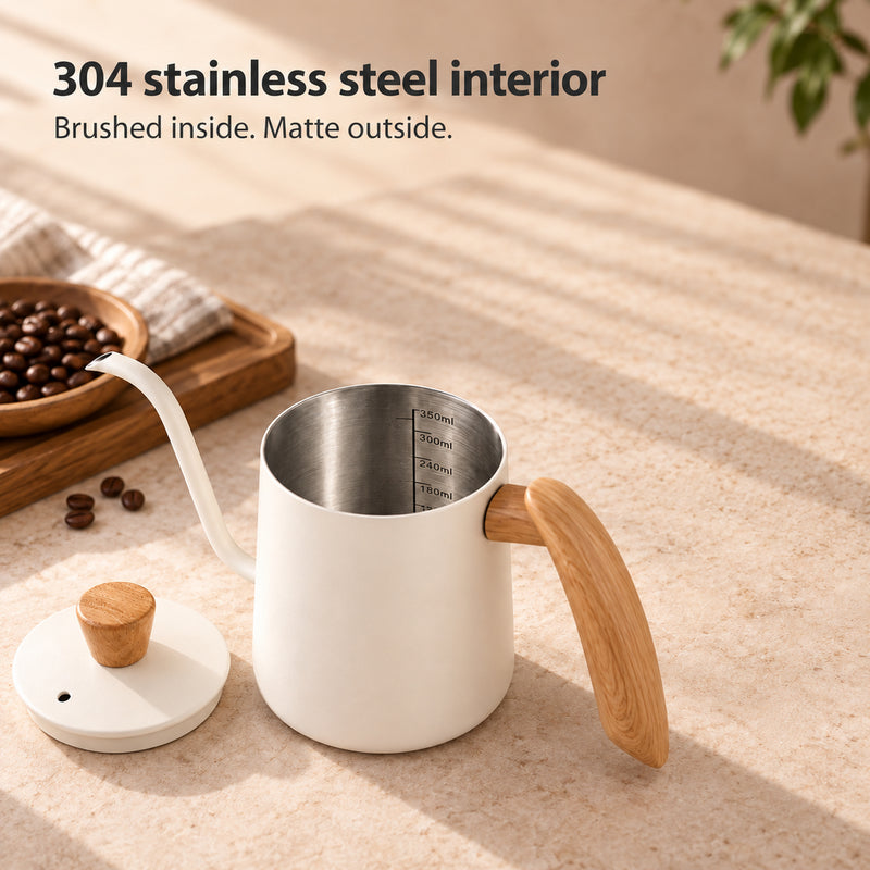 Open ivory white kettle showing a brushed 304 stainless steel interior and volume markings, with its lid beside it.