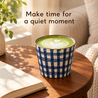 Blue and ivory gingham ceramic cup filled with matcha latte beside a book