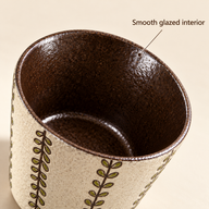 Close-up of the dark brown glazed interior and rounded rim of the Olive Vine cup.