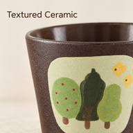 Close-up of the brown textured ceramic surface and green tree artwork