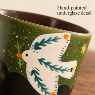 Nahaufnahme der Tasse Vogel mit Blättern mit weißem Vogel, petrolfarbenen Blattmotiven und grüner strukturierter Keramik.