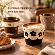 Tasse en céramique de 300 ml à motif floral noir avec un latte sur une table en bois ensoleillée dans un café