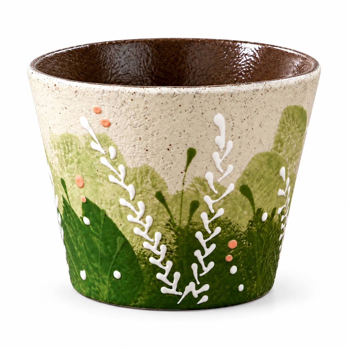 Henkellose Keramik-Kaffeetasse mit Wiesenmuster, grünem Laub und weißen Zweigen auf weißem Hintergrund.
