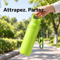 Gourde verte de 620 ml portée par la poignée intégrée du couvercle dans une allée de parc