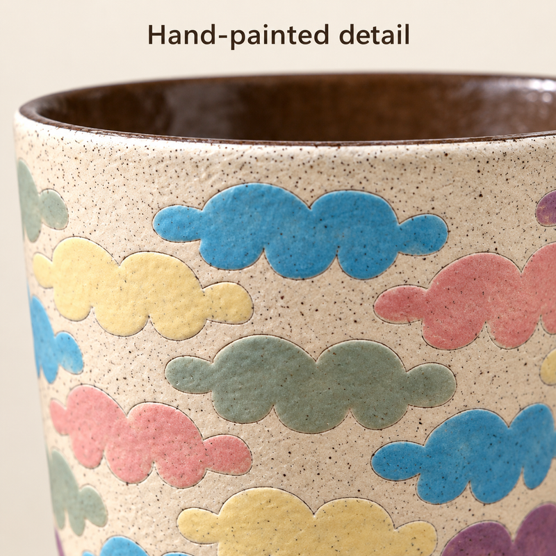 Close-up van de pastelkleurige wolkenmotieven en fijne stipjes op de wand van een keramische kop.