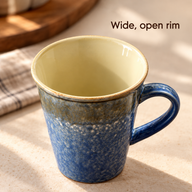 Close-up of the wide rim and cream glazed interior of the mottled blue mug
