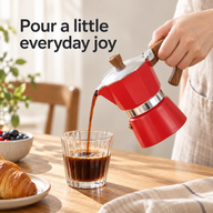 Cafetière italienne rouge de 150 ml versant du café dans un verre strié à la table du petit-déjeuner