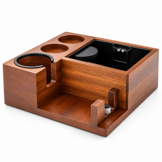 Estación de prensado para espresso de madera de sapeli con cajón de posos vacío, dos huecos para utensilios y soporte regulable para el mango sobre fondo blanco.