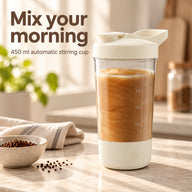 Cream automatic stirring cup with a coffee drink on a sunlit kitchen counter