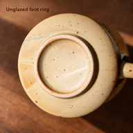 Underside of the amber and ivory ceramic mug showing the unglazed foot contact ring