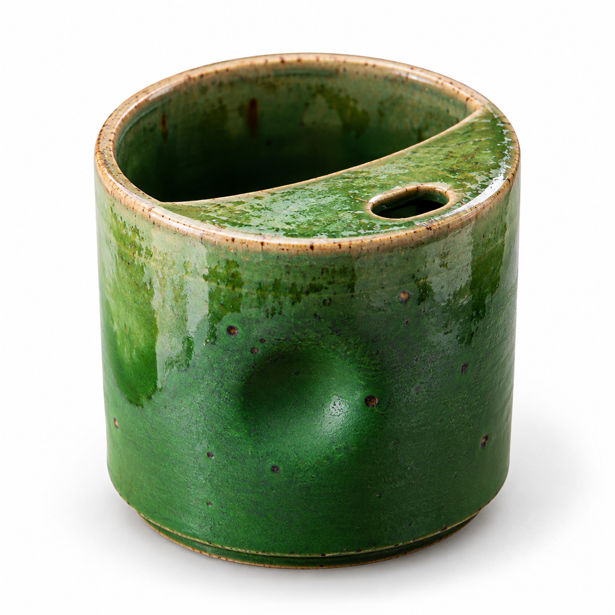 Small green reactive-glaze ceramic coffee cup with thumb indentation and integrated crescent sip rim on a white background.