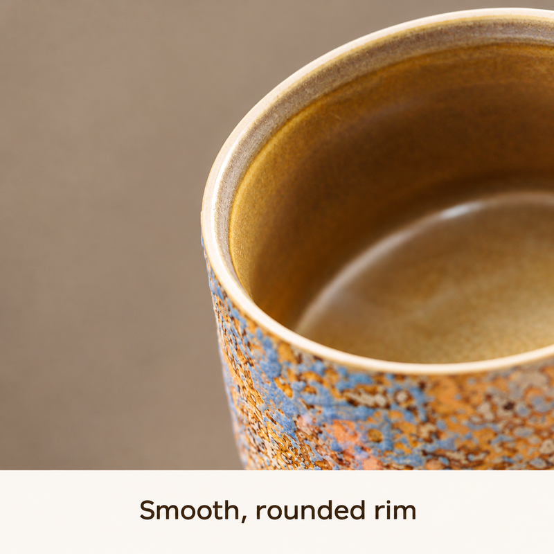 Close-up of the rounded pale rim and brown-gold glazed interior of the ceramic mug