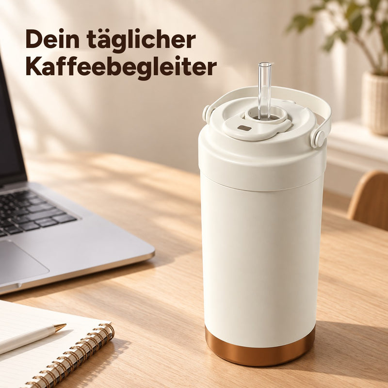 Cremeweißer Kaffeebecher mit Glasstrohhalm auf einem Schreibtisch neben einem Laptop