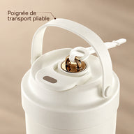 Gros plan sur le couvercle de la tasse blanc crème, la poignée de transport pliable et le bouchon doré