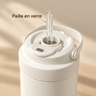 Paille en verre transparente insérée dans l’ouverture du couvercle de la tasse blanc crème