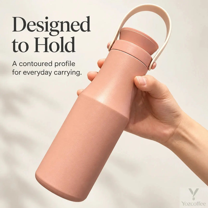 Hand holding the peach insulated bottle by its contoured upper body