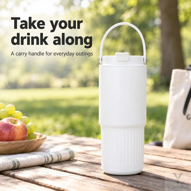 White 750ml insulated tumbler with carry handle on an outdoor picnic table