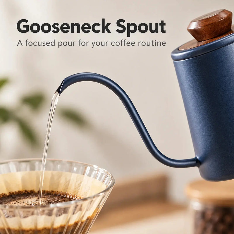 Close-up of the Prussian blue kettle's curved gooseneck spout pouring a stream of water