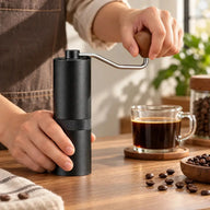 Kaffee von Hand mit der schwarzen Handmühle mahlen