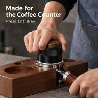 Black walnut tamper pressed in a portafilter at a coffee counter