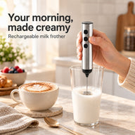 Silver rechargeable handheld milk frother in use beside a morning cappuccino
