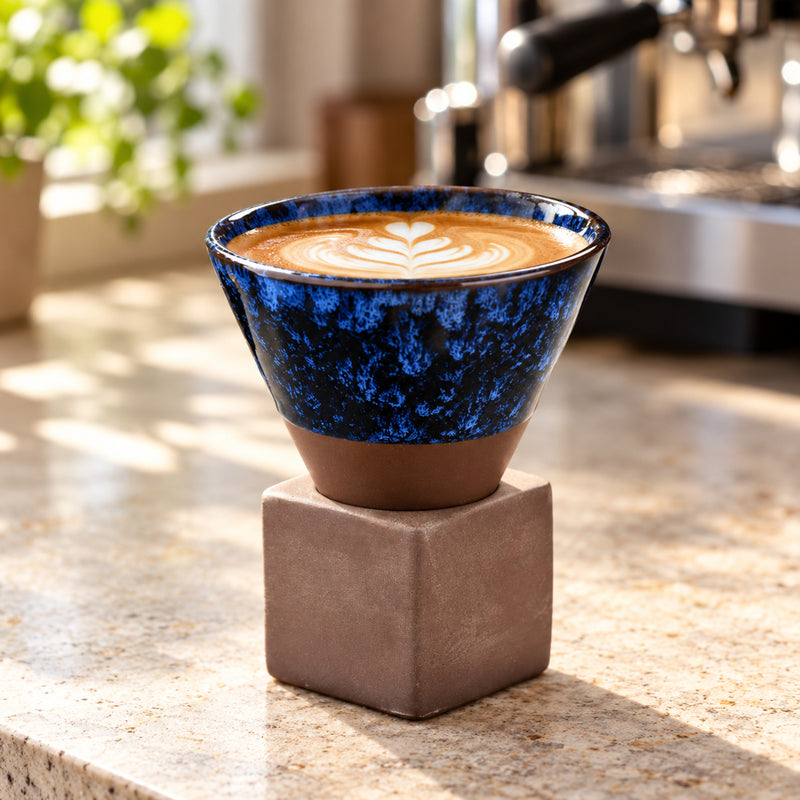 Deep Blue kiln-glazed ceramic coffee cup holding latte on a kitchen counter