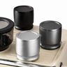 58mm dosing cup and distributor shown in silver, dark gray, and black color options on an espresso drip tray