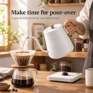 White wood-grain handle gooseneck kettle pouring water into a glass coffee dripper