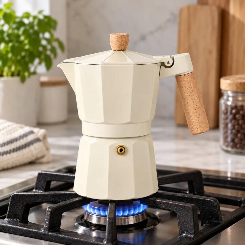 Cream moka pot brewing on a gas stove